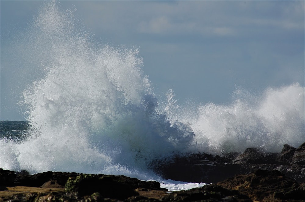 ocean waves crashing on rocks during daytime