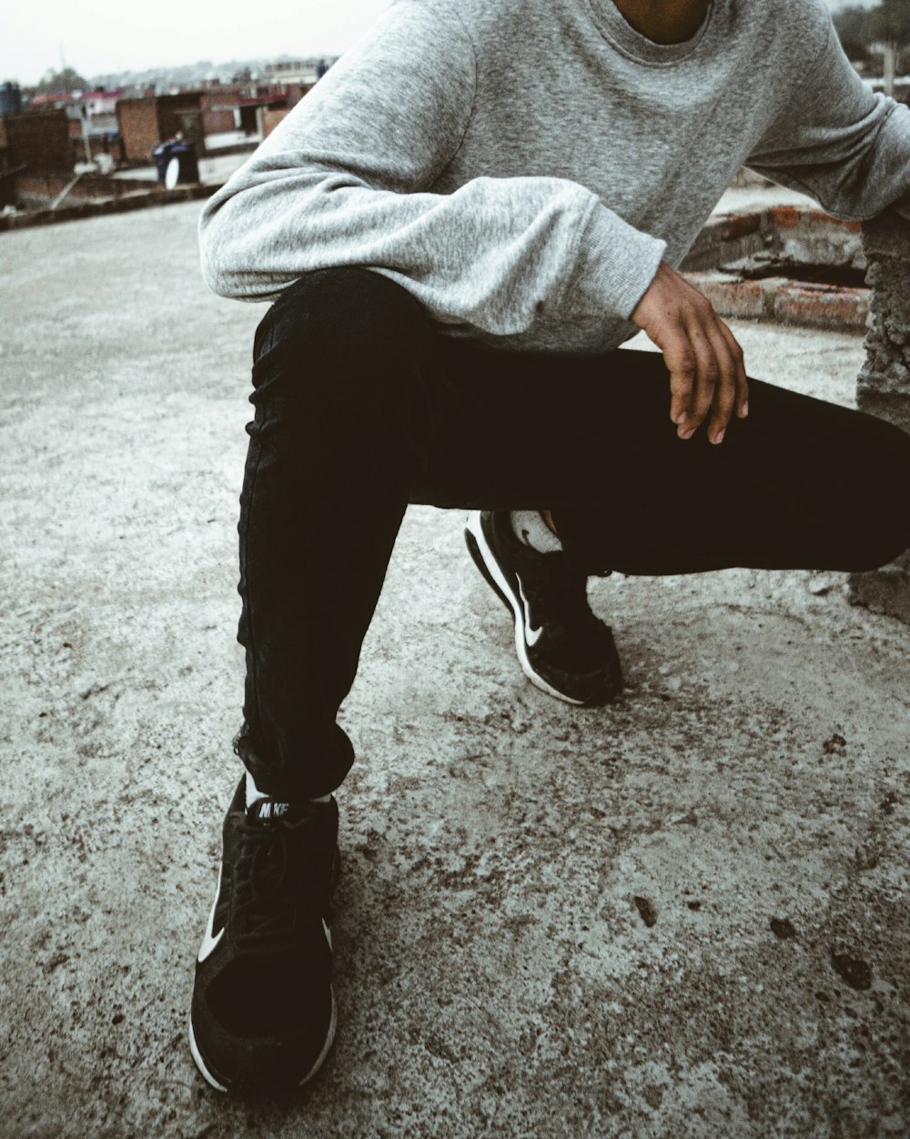 man in gray sweater and black pants sitting on bench during daytime