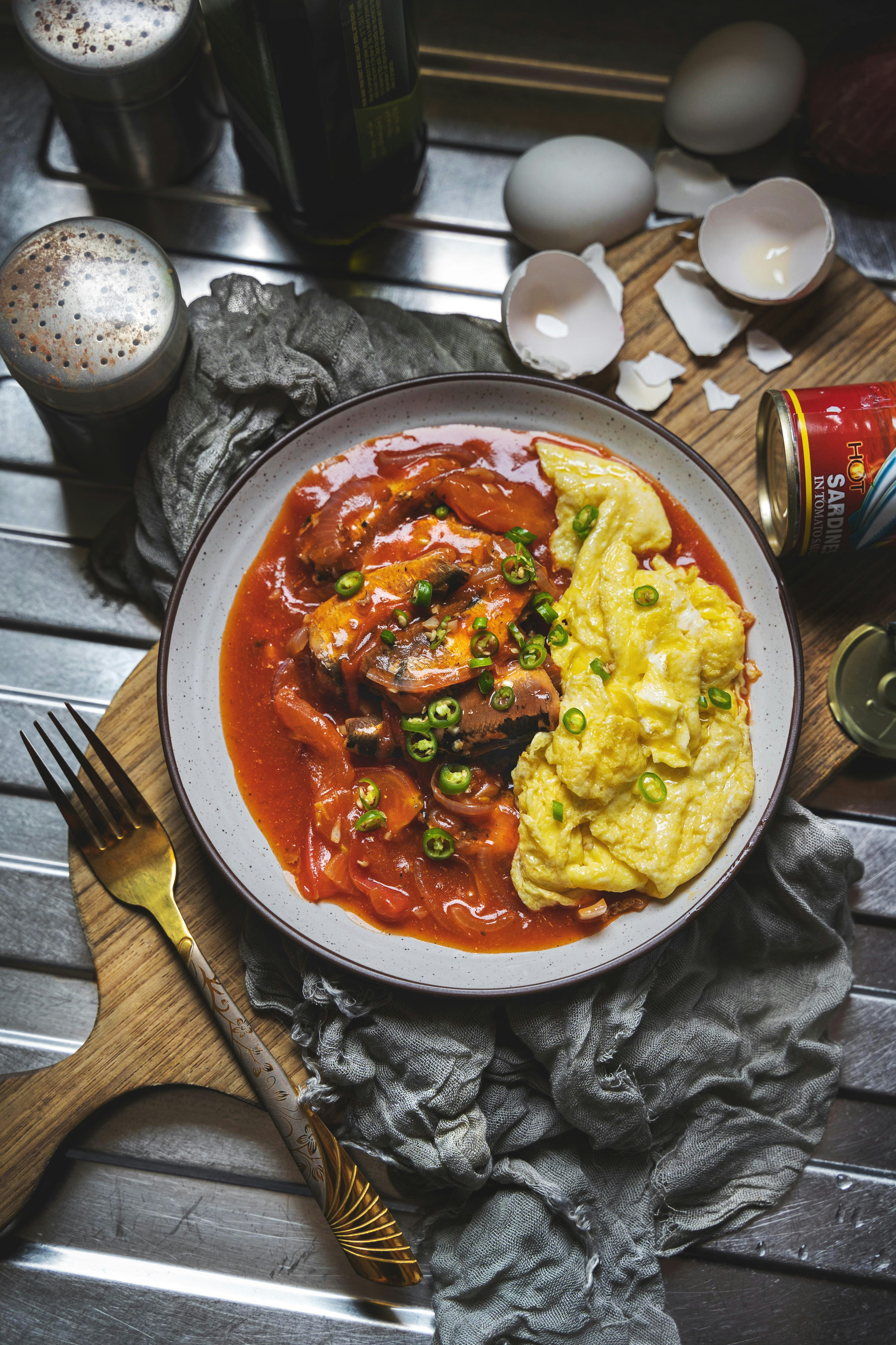 cooked food on round ceramic bowl beside stainless steel fork and knife