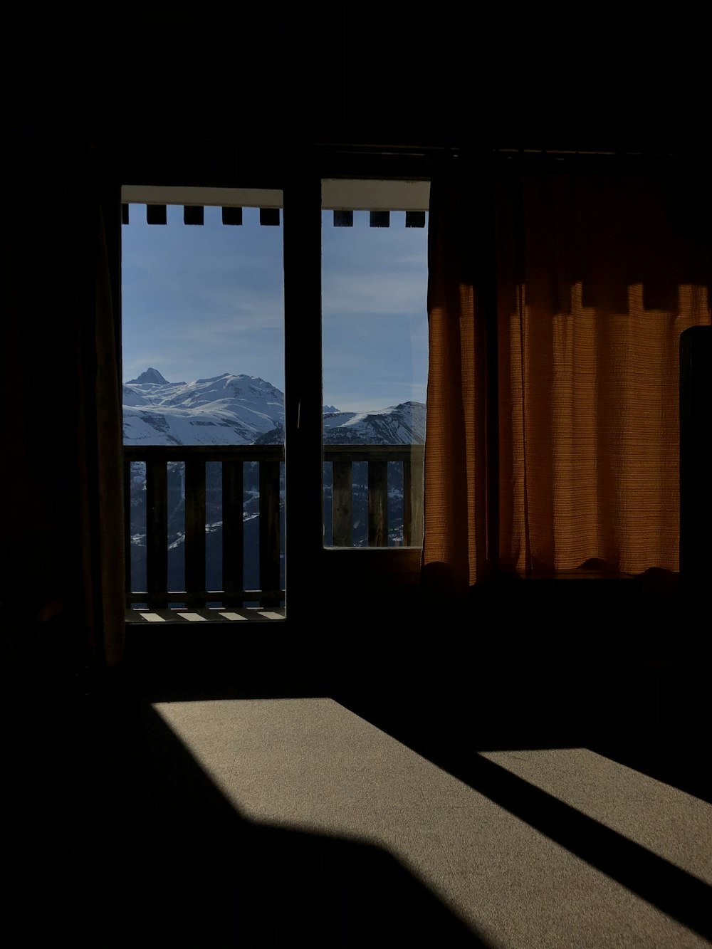 brown window curtain near snow covered mountain during daytime