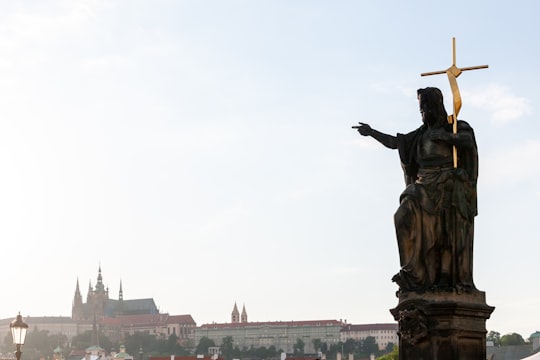 statue of man holding book in Praha Czech Republic