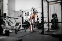 man in orange tank top and black shorts doing exercise