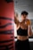 woman in black sports bra and black shorts holding orange bottle