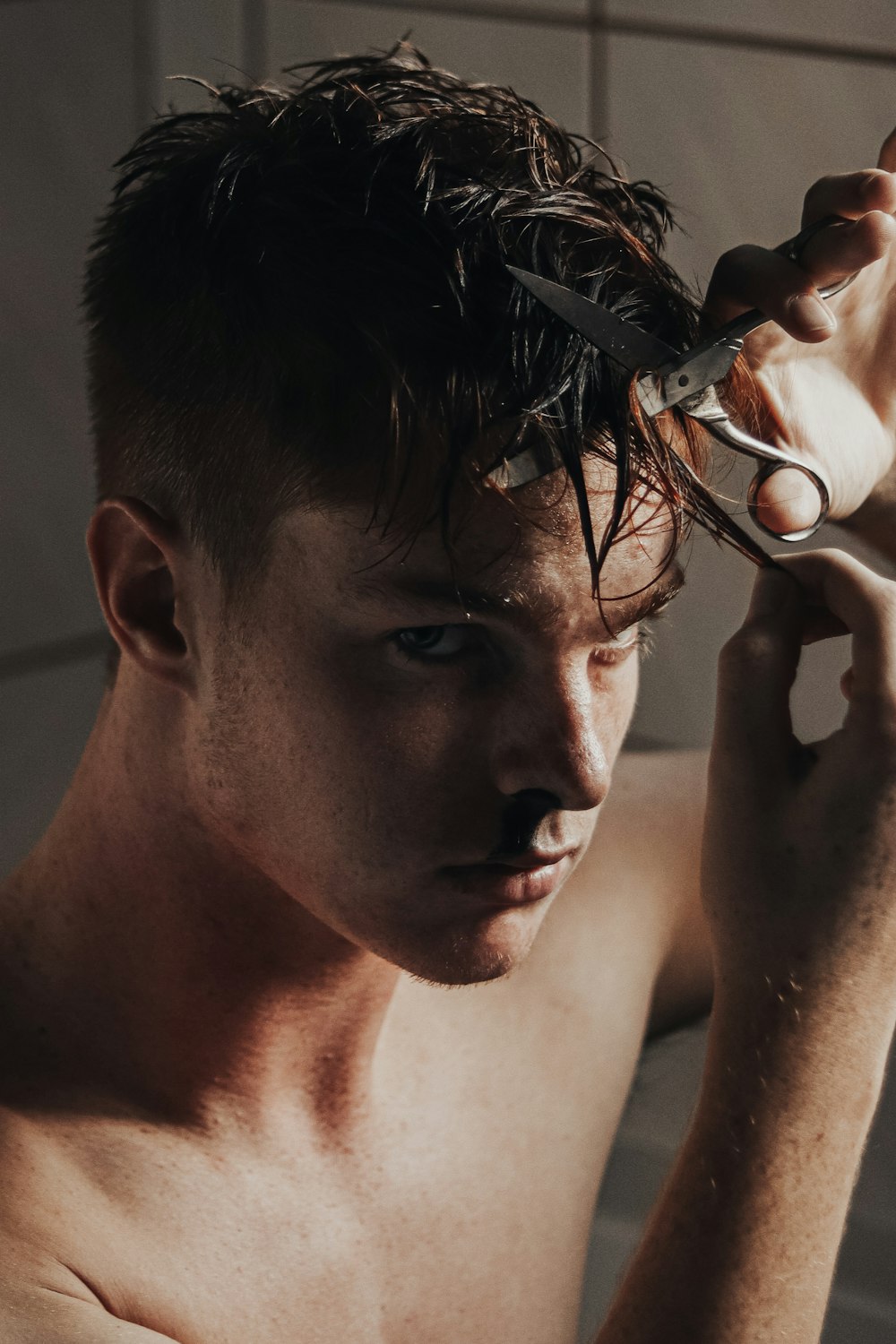 man with black hair holding hair iron