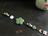 A collection of green and white charms displayed on a soft linen cloth.