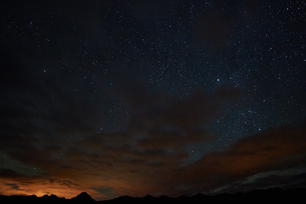 silhouette of mountain under starry night