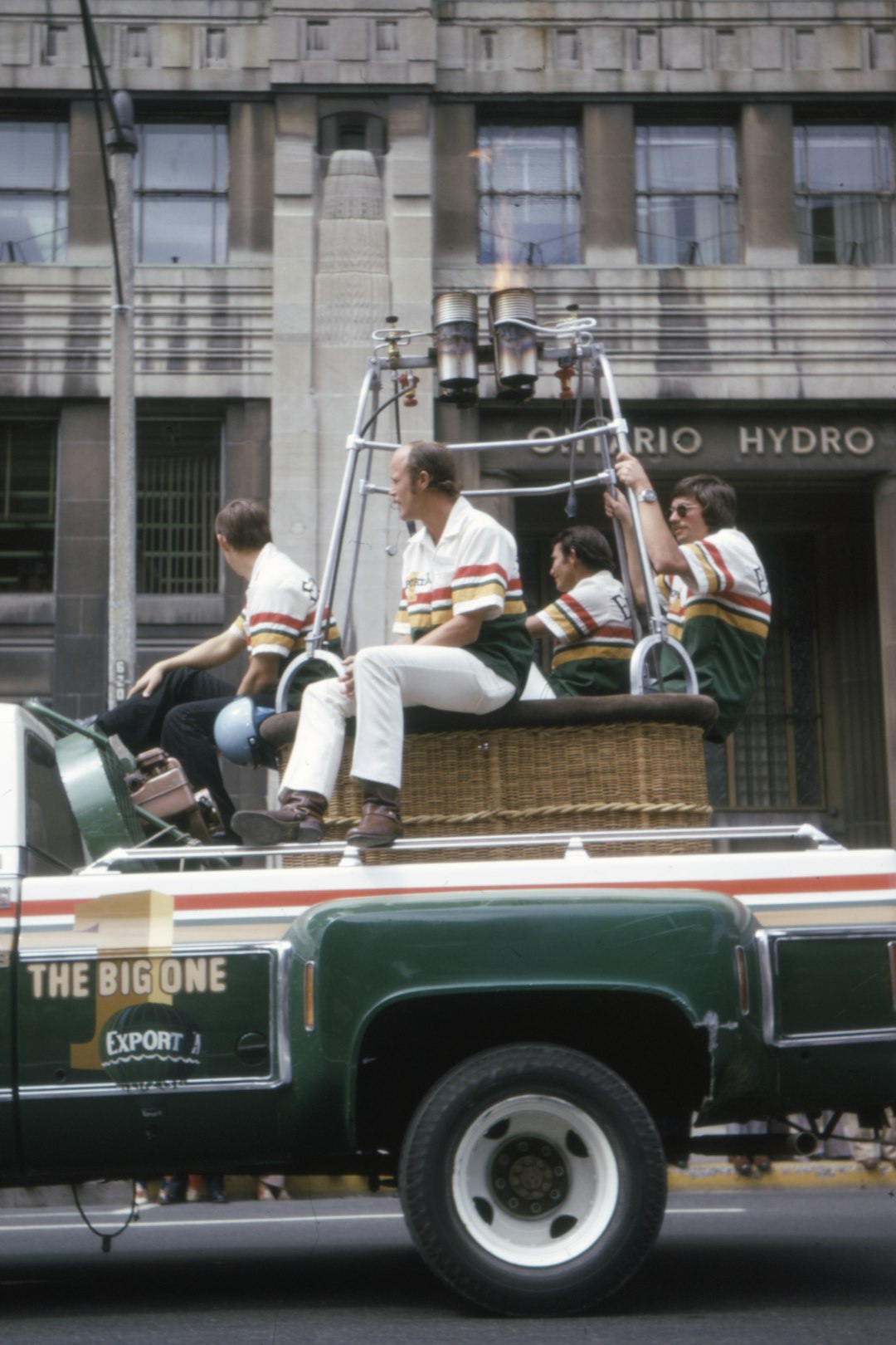 man in white long sleeve shirt sitting on green and white truck during daytime