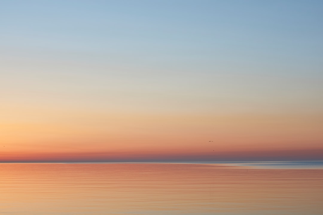 calm sea under blue sky during daytime