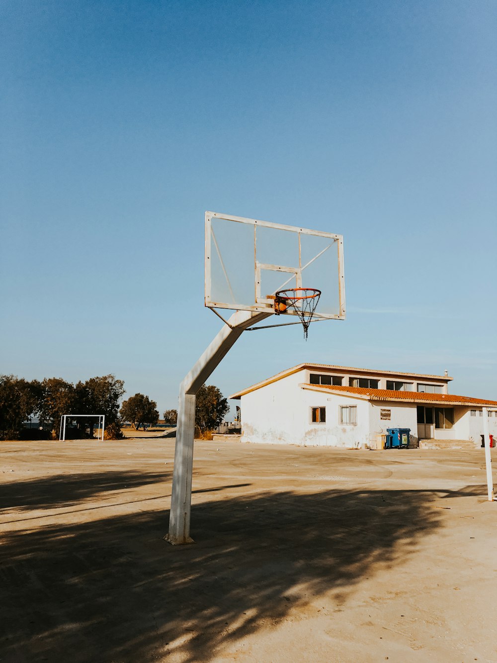 Aro de baloncesto frente al edificio blanco durante el día