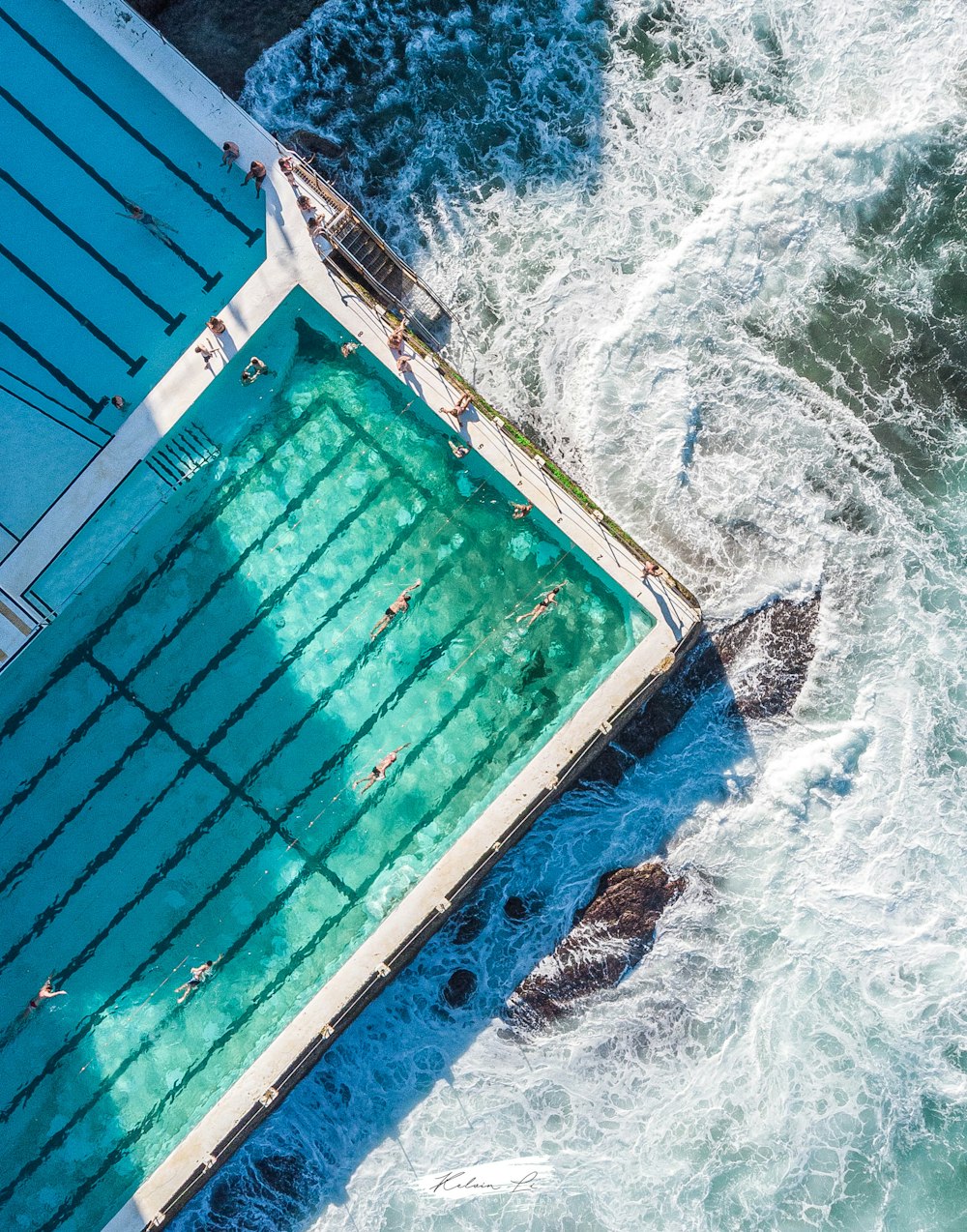 낮에는 파란색과 흰색 바다 옆에 있는 파란색과 갈색 수영장