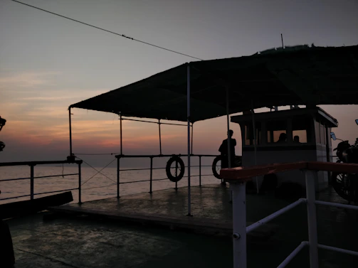 Crew members coordinating on deck during a ship charter operation at sunset.