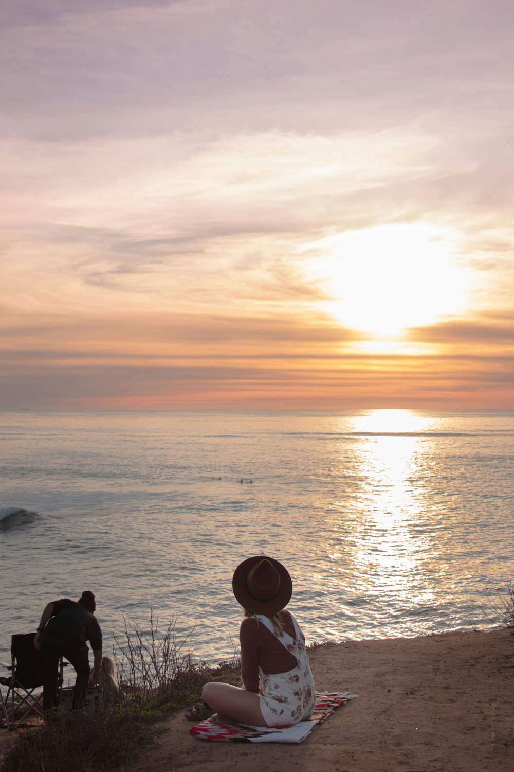 Silhouette von Menschen, die während des Sonnenuntergangs am Meeresufer stehen