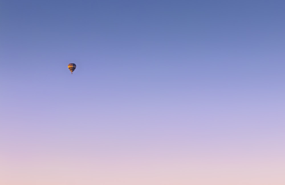 red and yellow hot air balloon in mid air during daytime