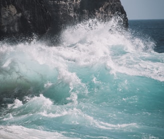 ocean waves crashing on rocky shore during daytime