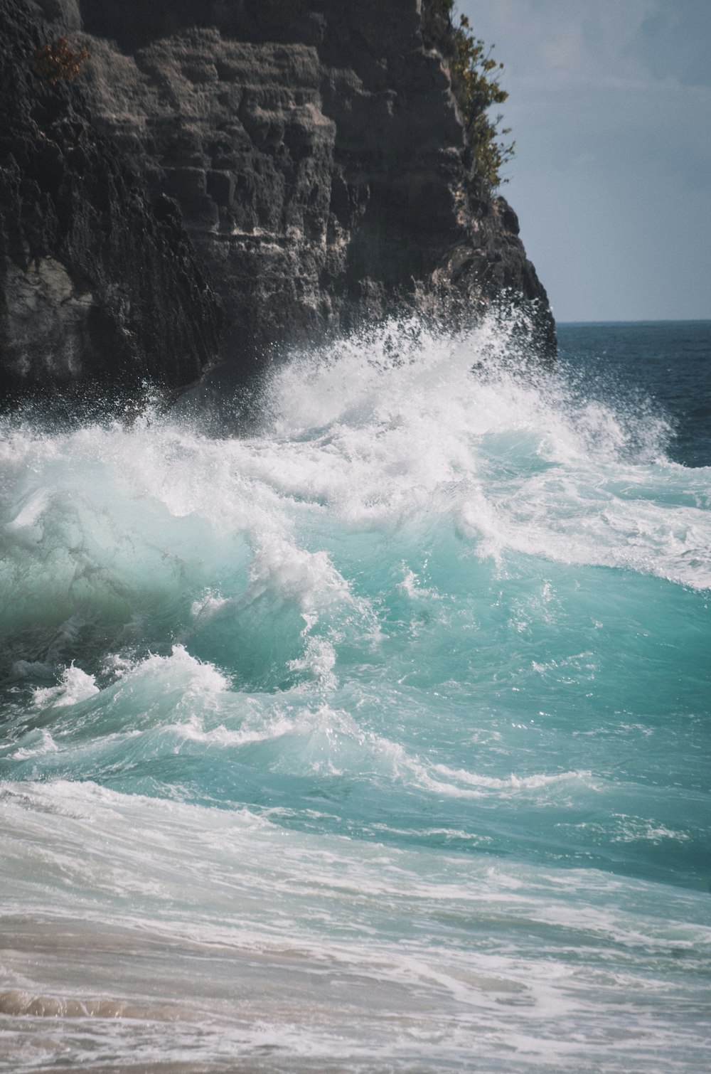 Les vagues de l’océan s’écrasent sur le rivage rocheux pendant la journée