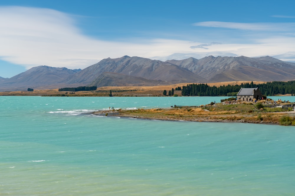 green and brown mountains beside body of water under blue sky during daytime