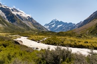 Snow-capped peaks of Sonamarg with a winding river below under a clear blue sky.