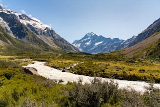 Snow-capped peaks of Sonamarg with a winding river below under a clear blue sky.