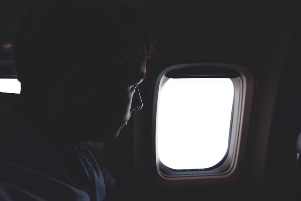 person looking at the window of airplane