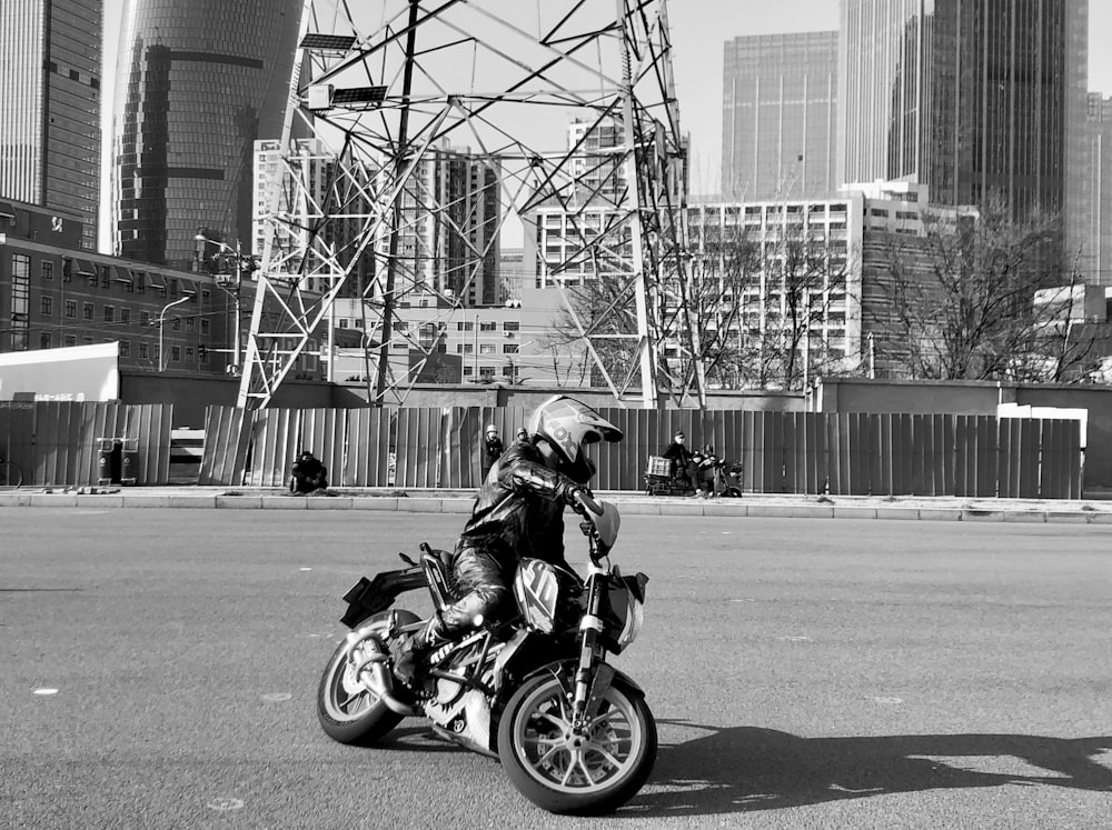 Foto en escala de grises de un hombre montando una motocicleta