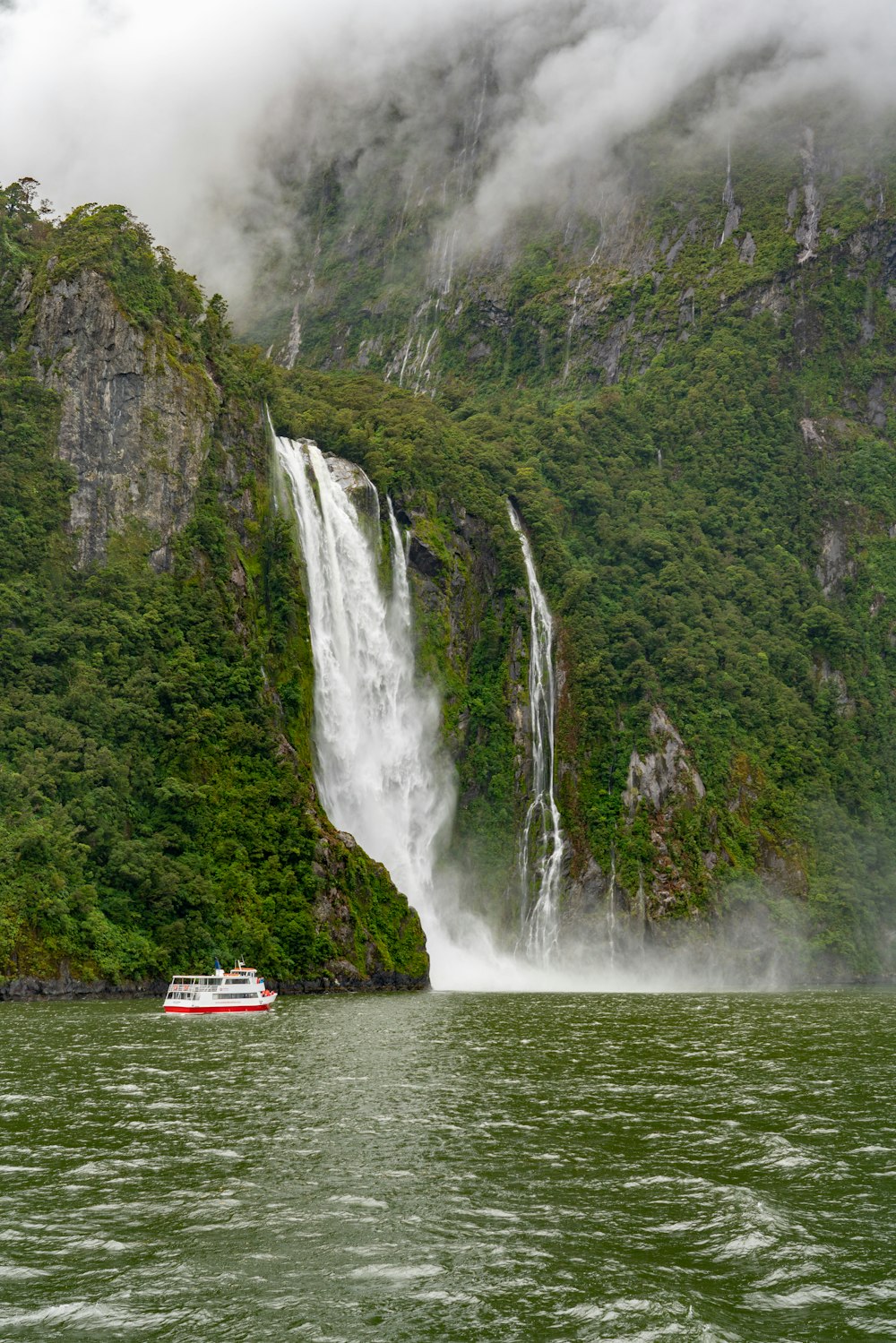 red boat on water falls during daytime