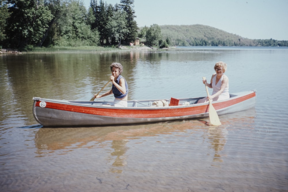 2 men riding on boat on lake during daytime