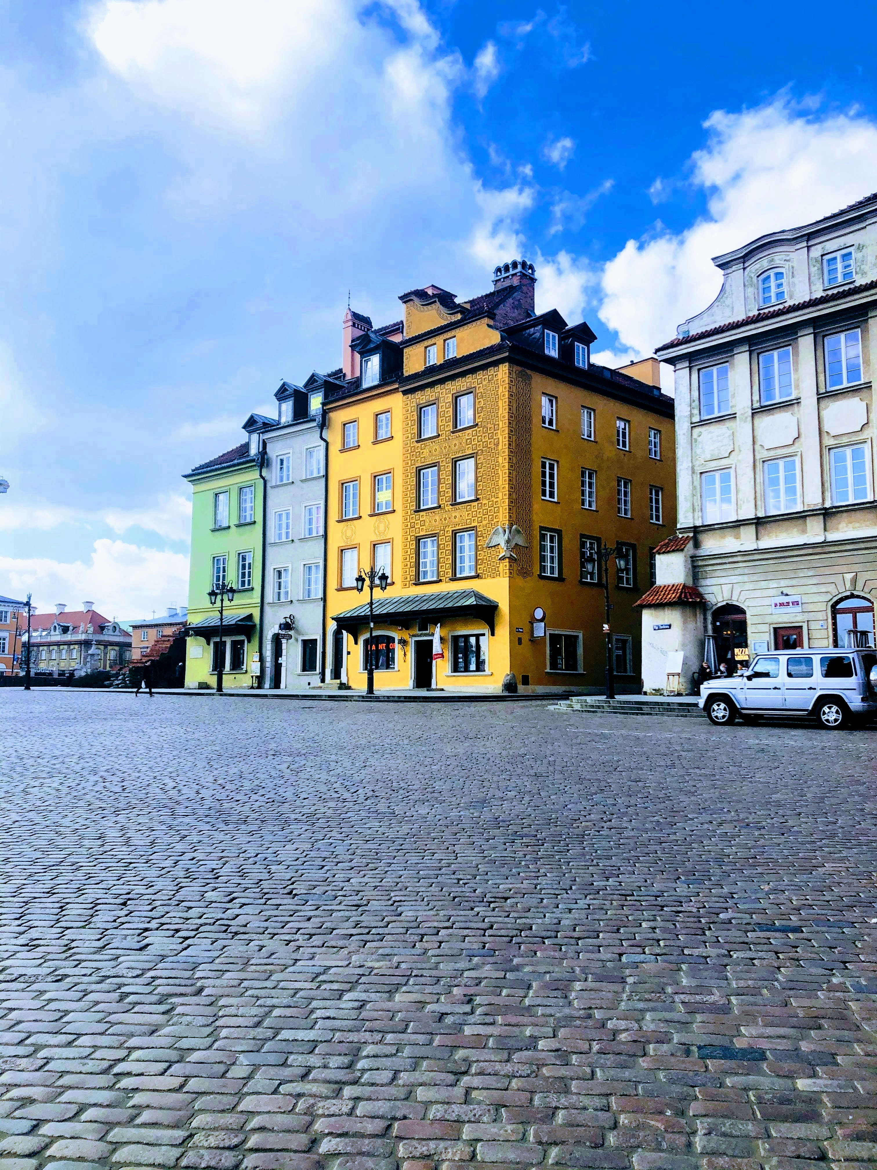 white van parked beside yellow and brown concrete building during daytime