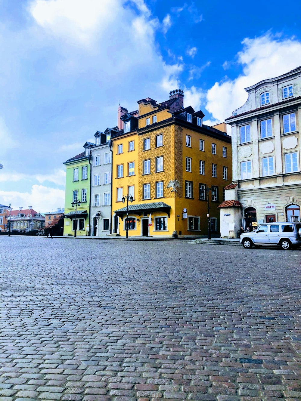 white van parked beside yellow and brown concrete building during daytime