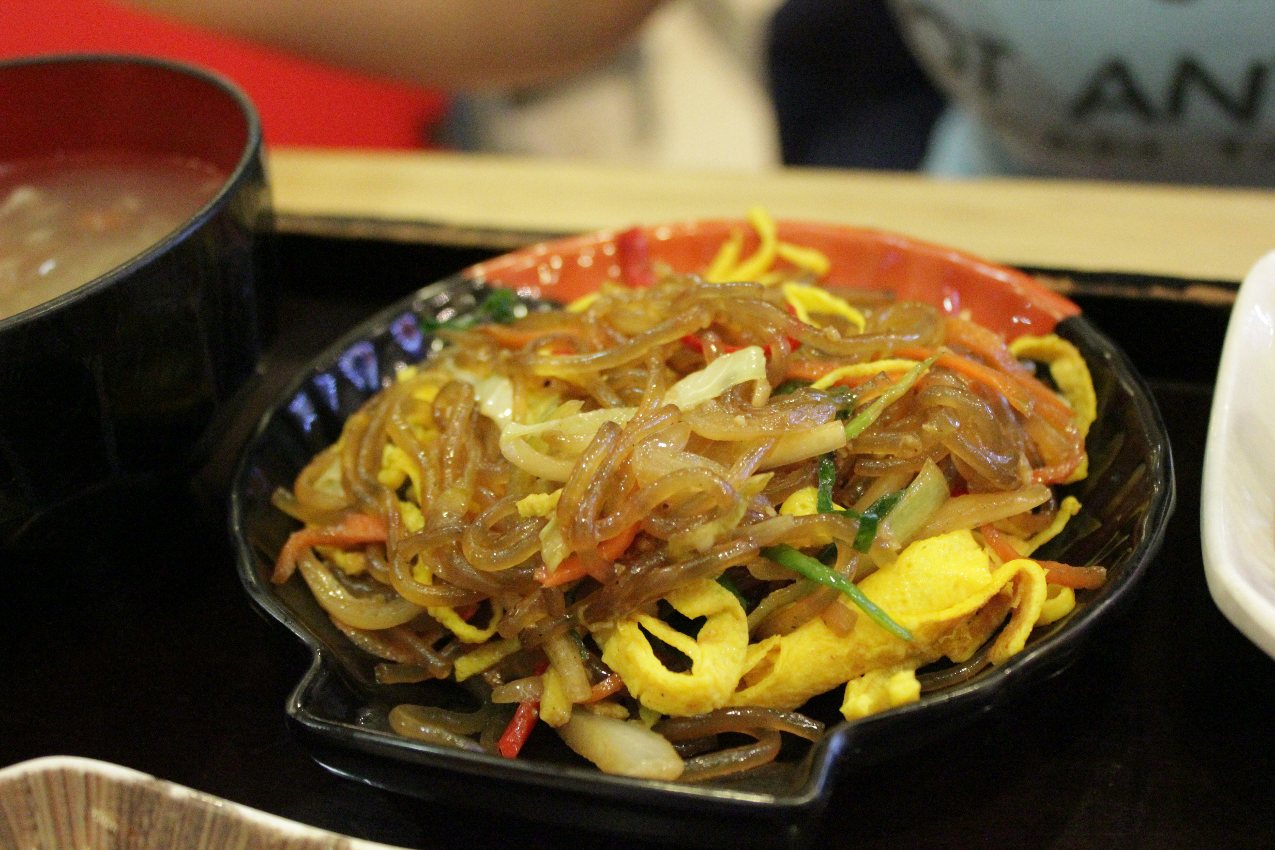 Korean glass noodle dish japchae with colorful stir-fried vegetables and sesame seeds on plate