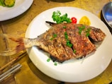 Grilled catfish served on a plate, garnished and ready to eat.