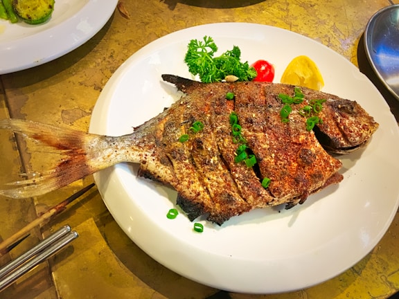 Grilled catfish served on a plate, garnished and ready to eat.