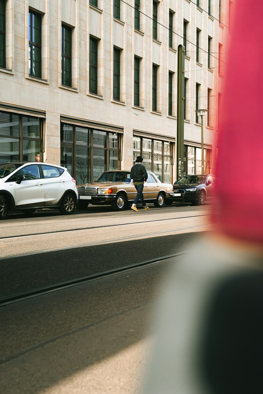 woman in black jacket and black pants sitting on gray car hood during daytime