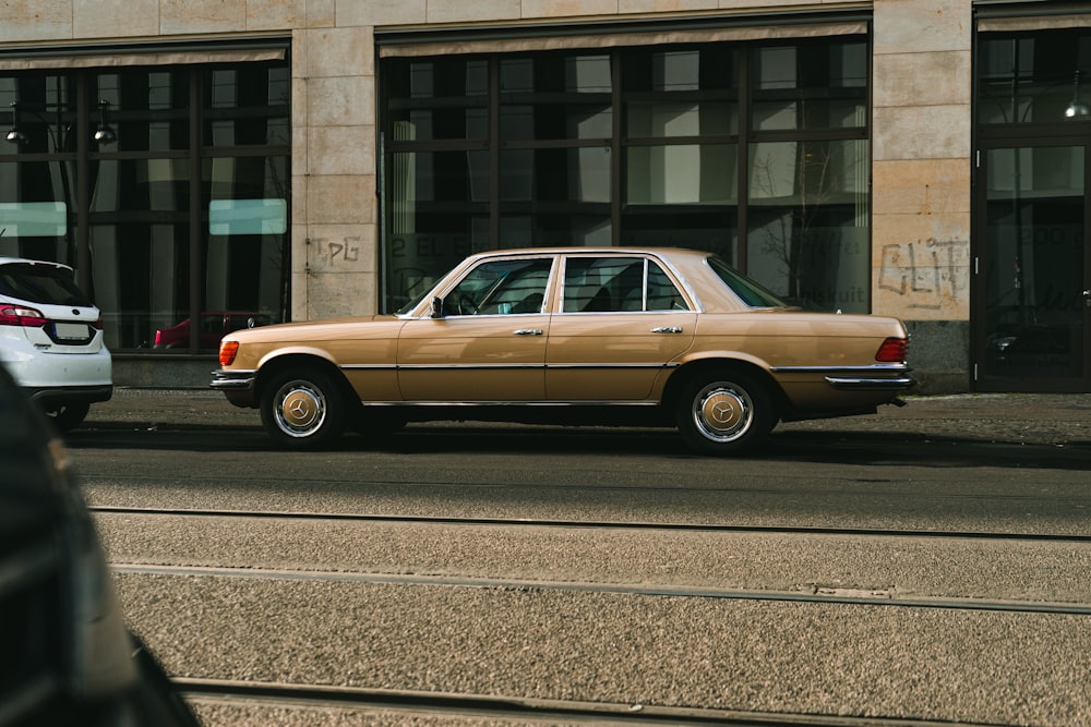 brown sedan parked on gray concrete road during daytime