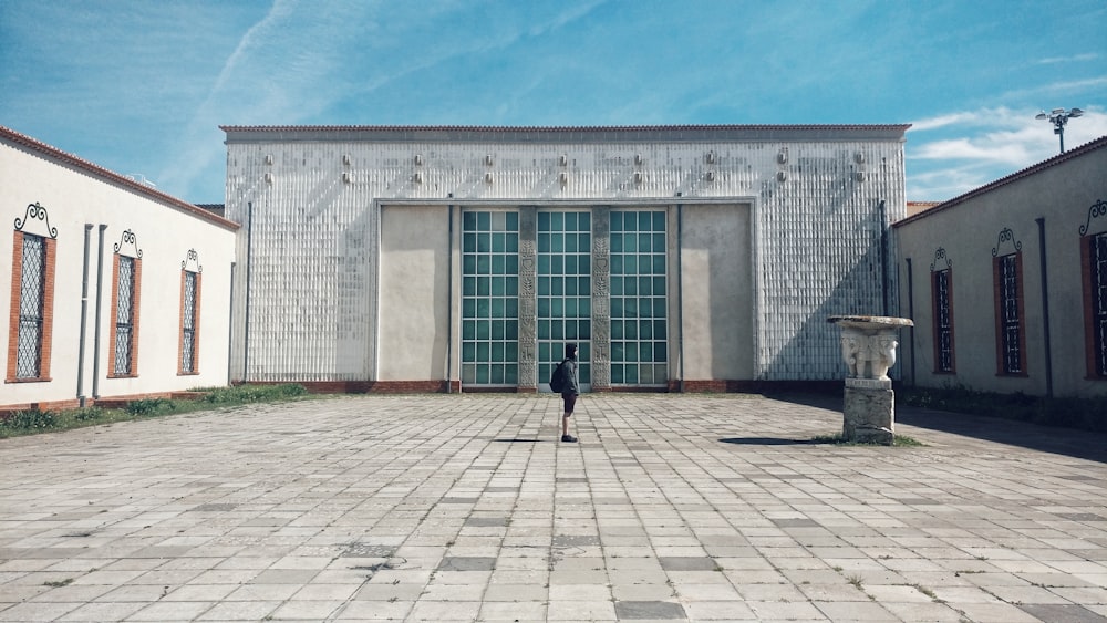 person walking on sidewalk near building during daytime