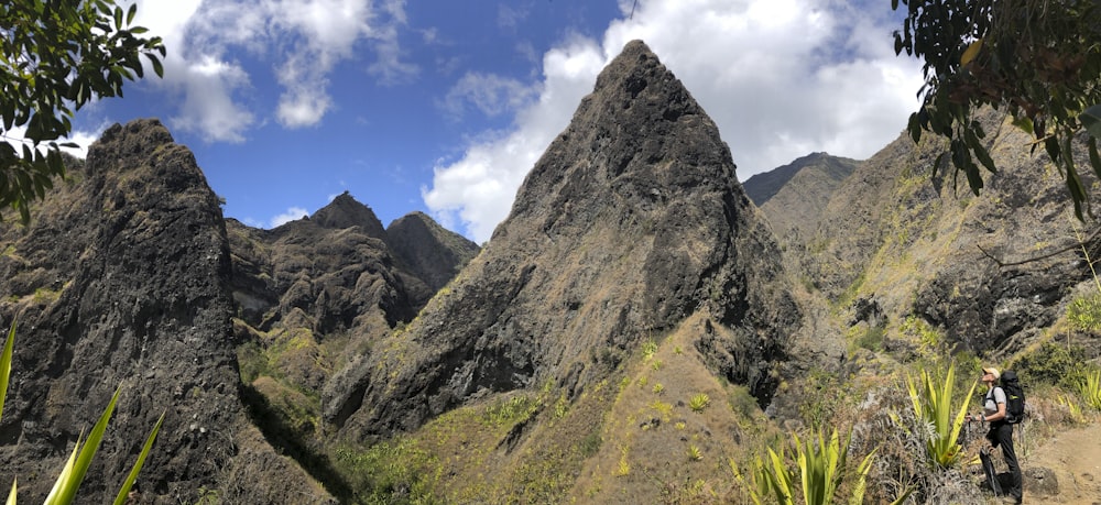 green grass and gray rocky mountain under blue sky during daytime