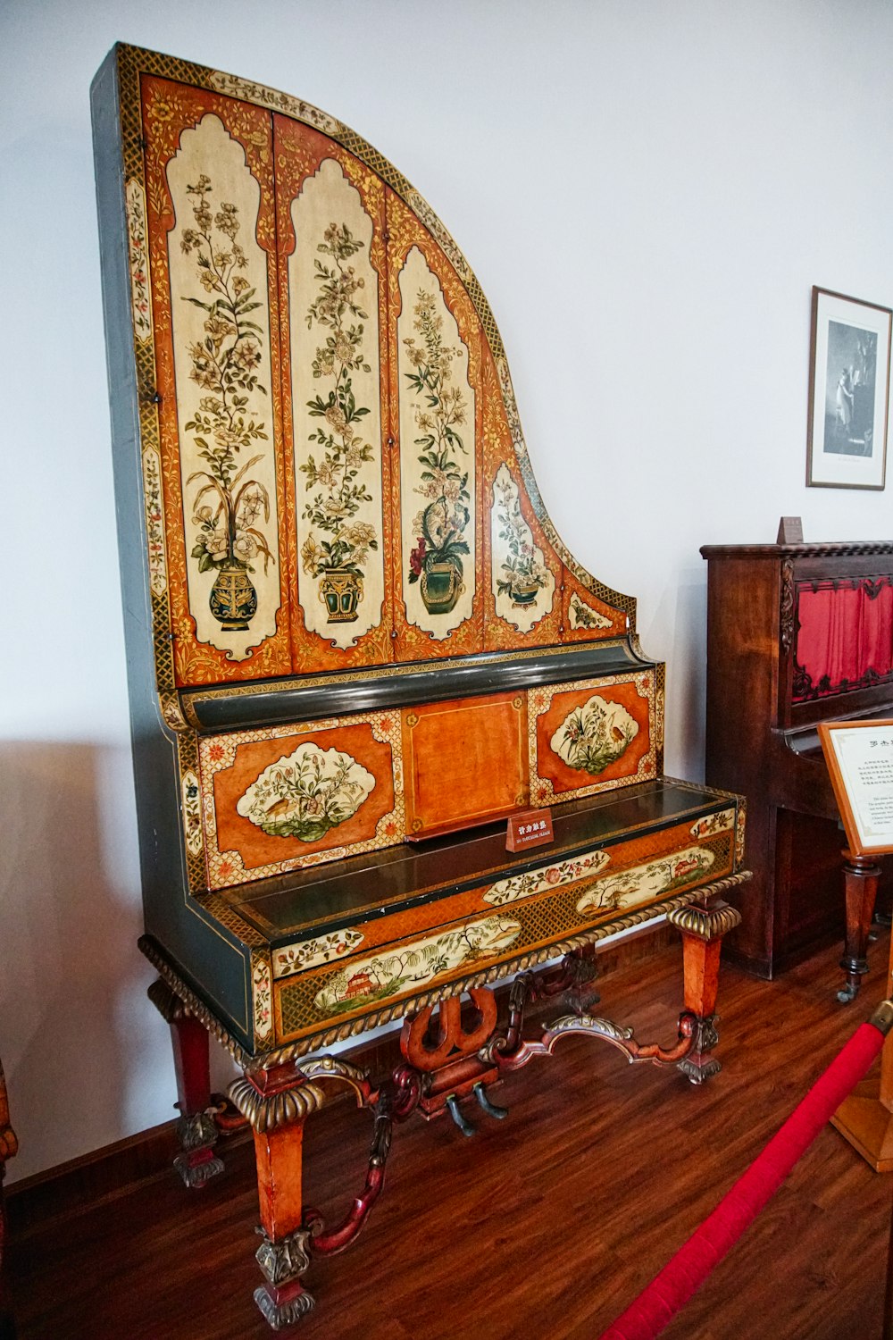 白い壁の横の茶色の木製のアップライトピアノ