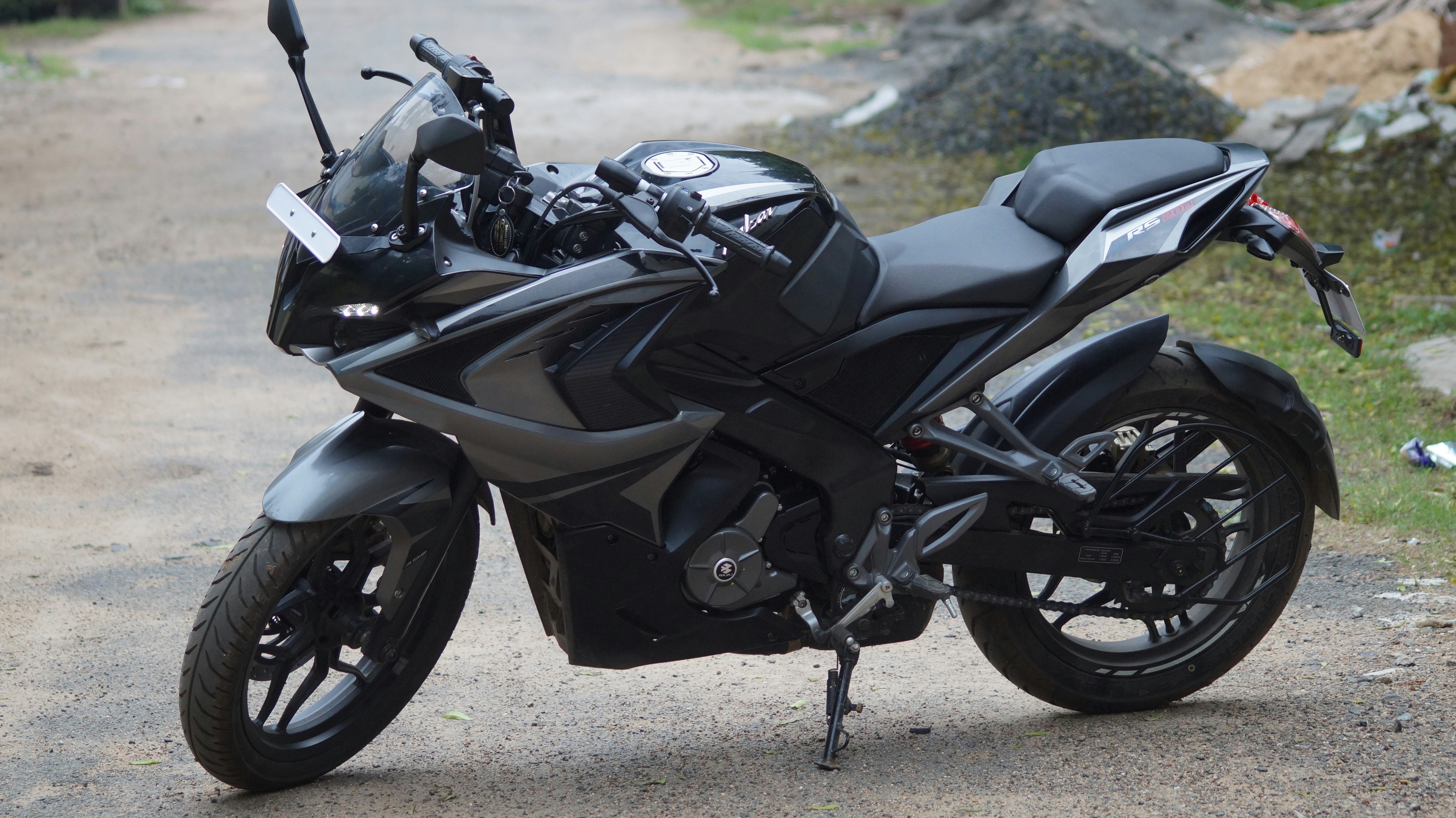 Sport motorcycle leaning into curve on mountain road, blurred background motion, aggressive aerodynamic fairing, dark metallic finish, cinematic speed blur