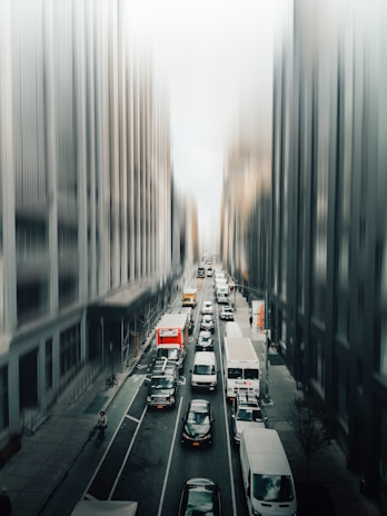 A busy city street with delivery vehicles in motion.