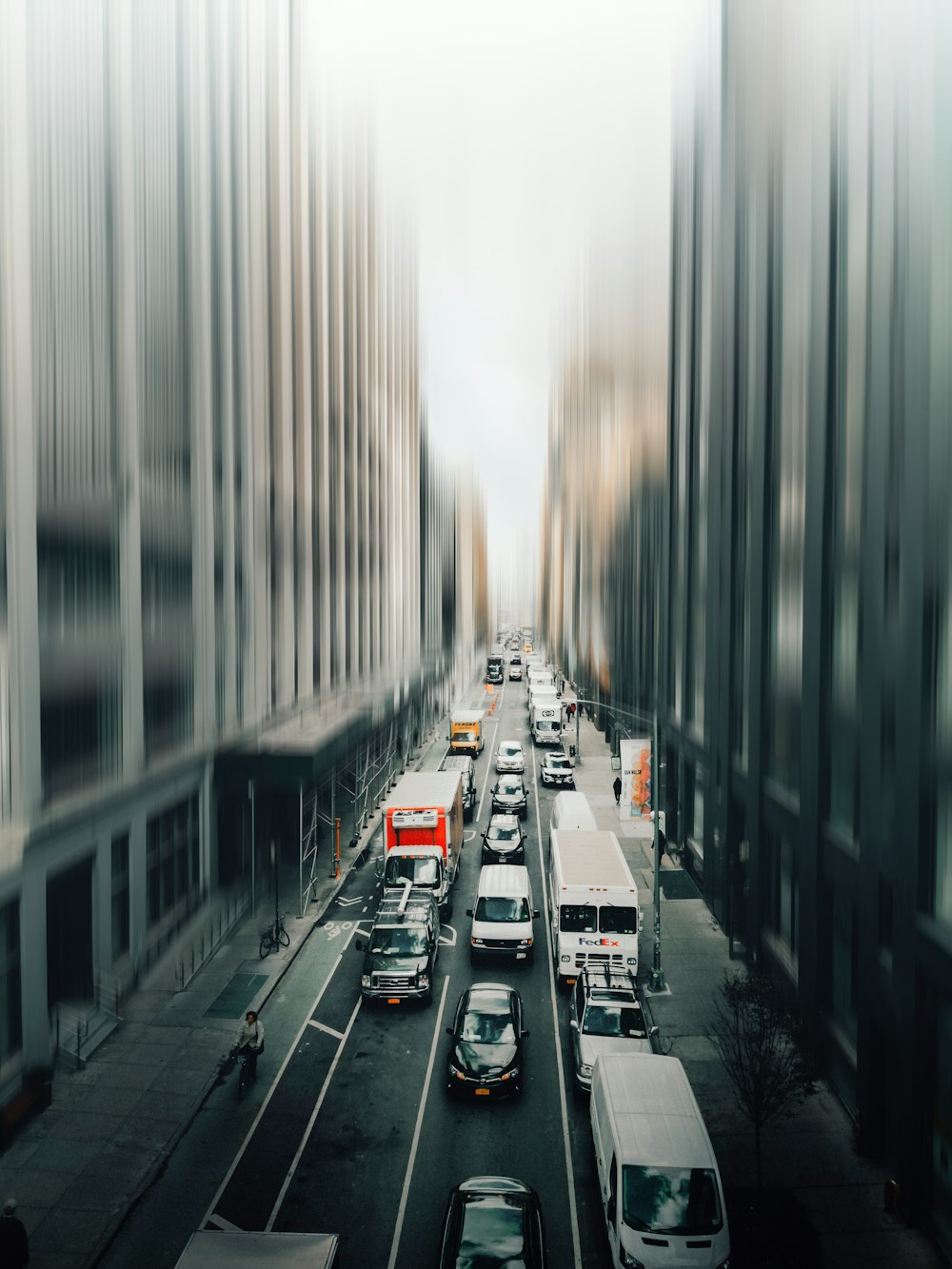 cars on road between high rise buildings during daytime