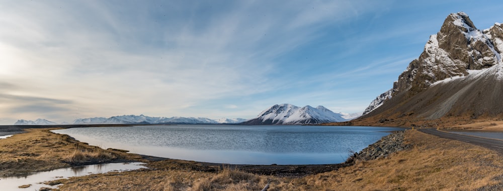 snow covered mountain near body of water during daytime