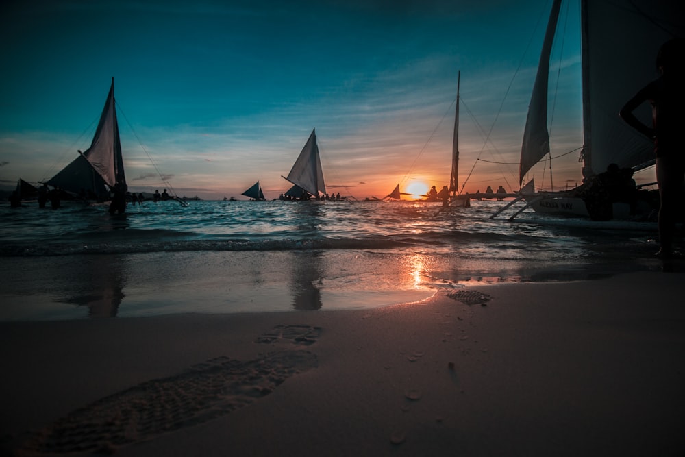 sail boat on sea shore during sunset