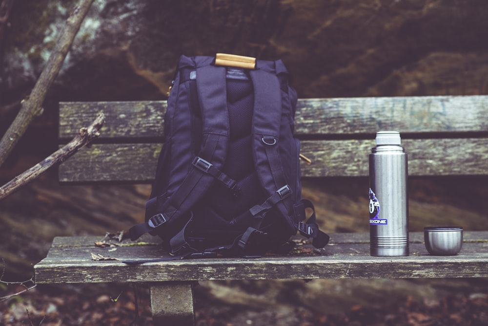 a backpack sitting on top of a wooden bench