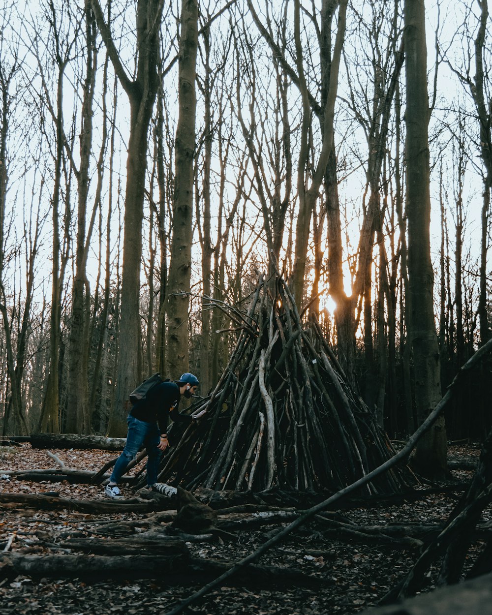 man in blue jacket and black pants walking on forest during daytime