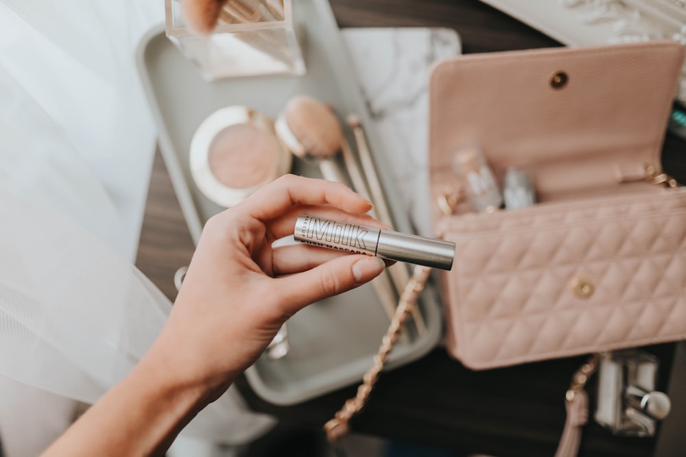 person holding silver tube type vape