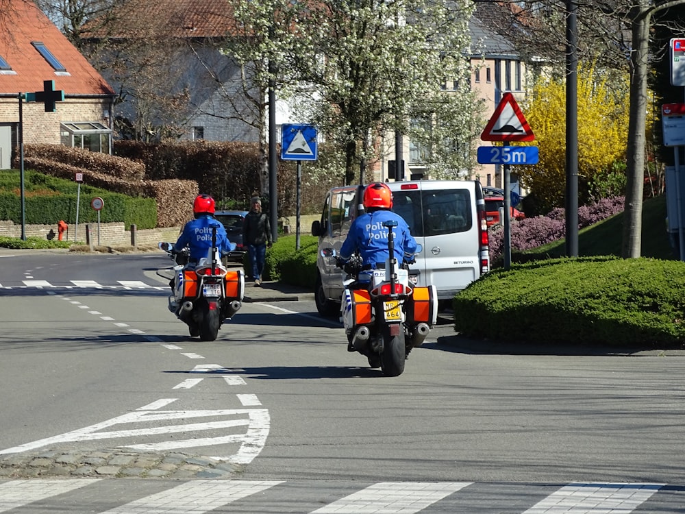 빨간 재킷을 입은 남자가 낮에 도로에서 오토바이를 타고 있습니다.