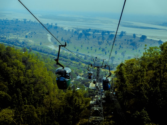 cable cars over green trees during daytime in Dehradun India