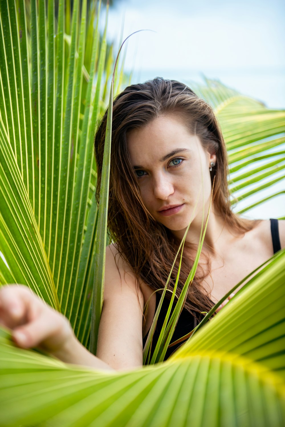 woman in green tank top holding green banana leaf