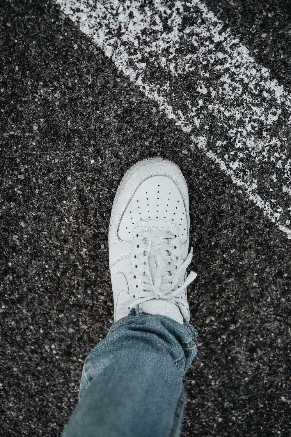 person wearing blue denim jeans and white nike sneakers