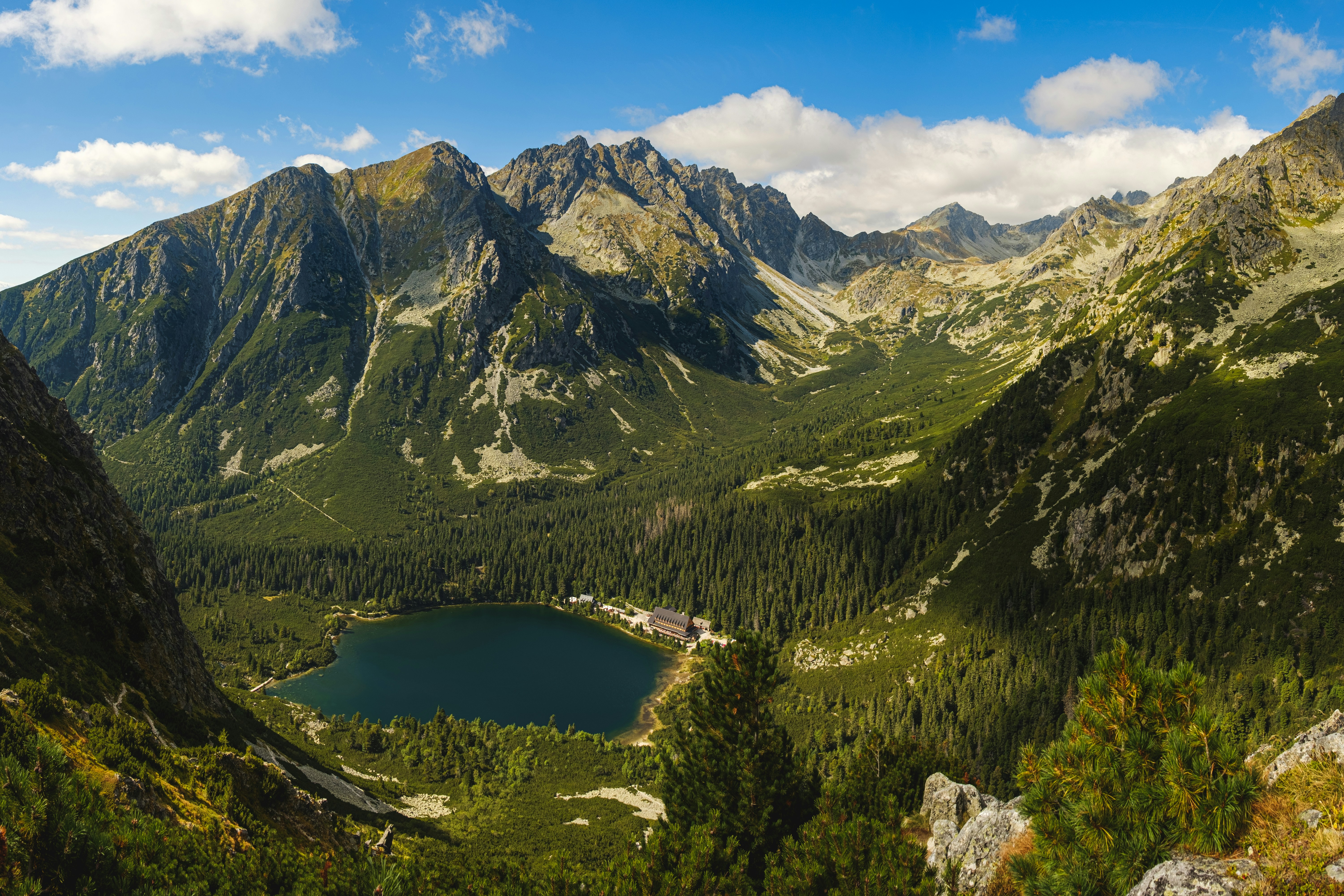 lake in the middle of green and brown mountains