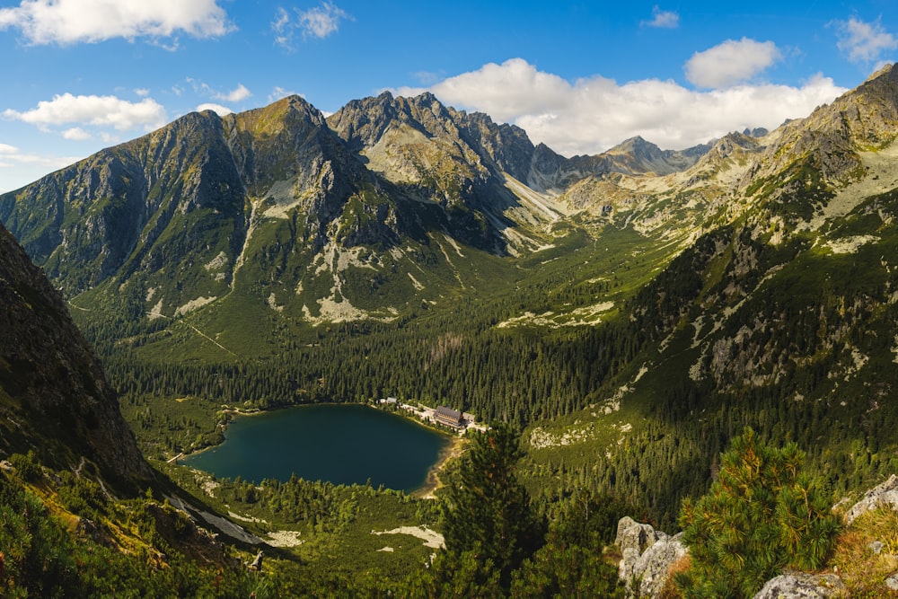 lake in the middle of green and brown mountains